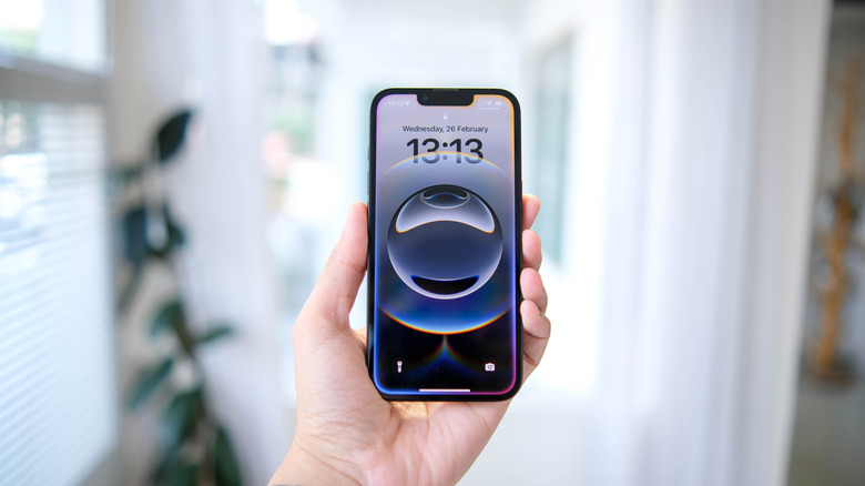 A person holding an iPhone, demonstrating the sleek design and secure grip.